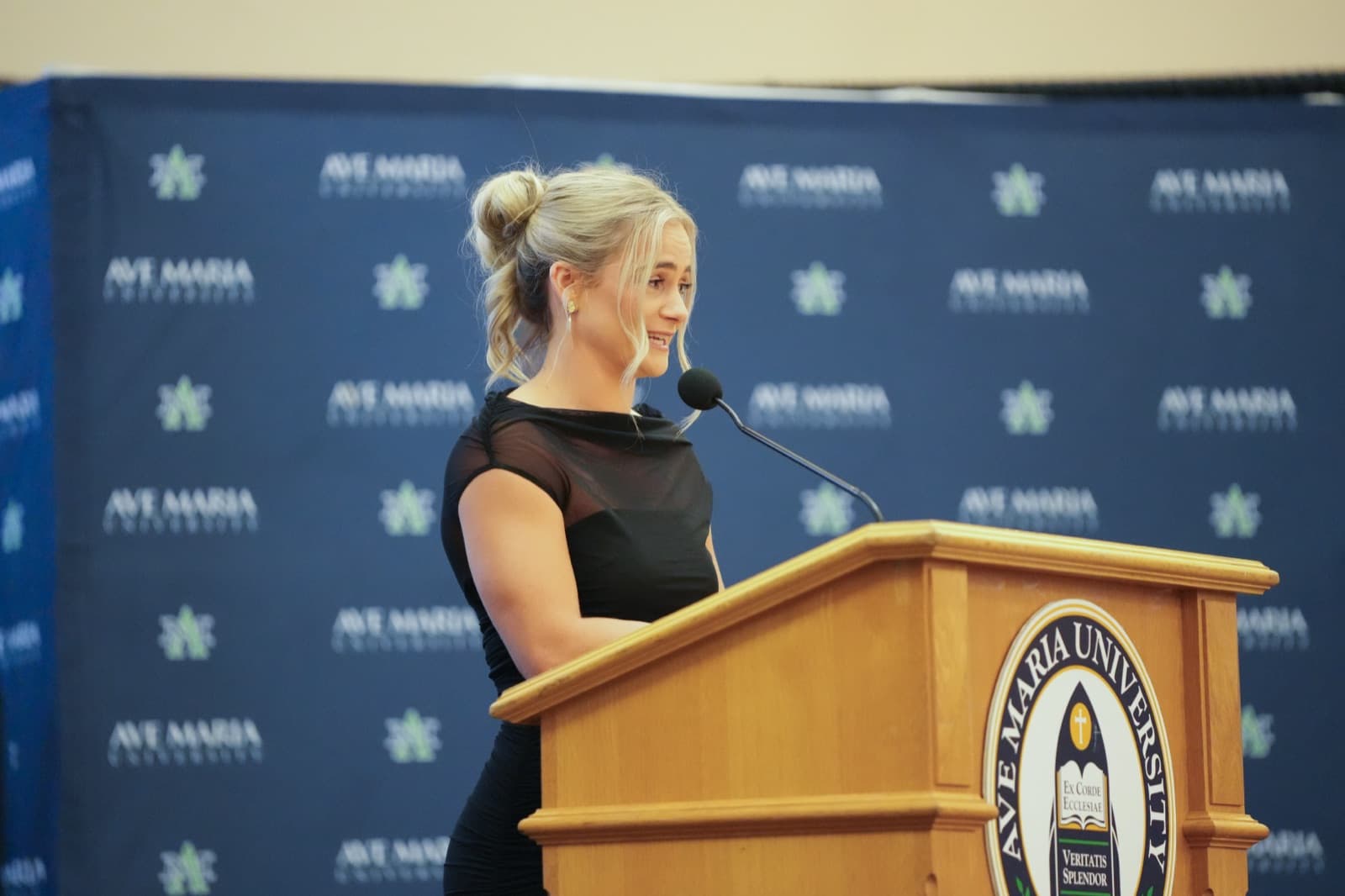 Hall of Fame inductee speaking at the podium during Homecoming Weekend
